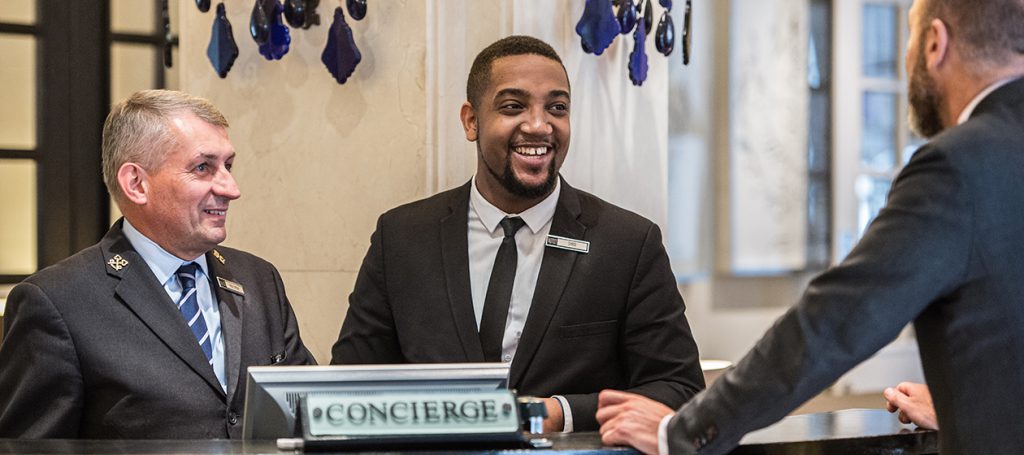 Three hotel concierge team members at reception desk