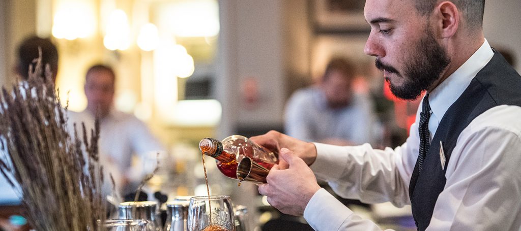 Close up of a bartender pouring wine into a glass