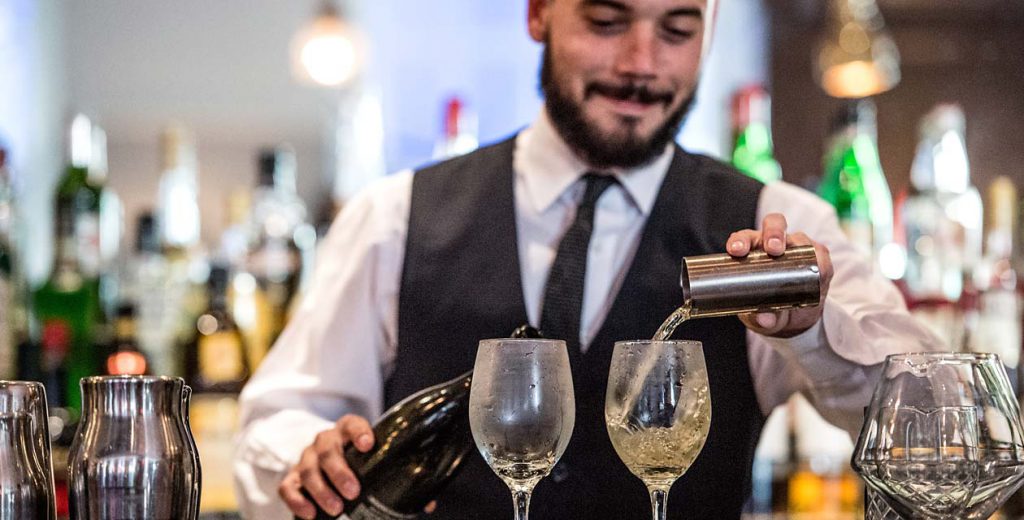 Bartender pouring wine into two glasses