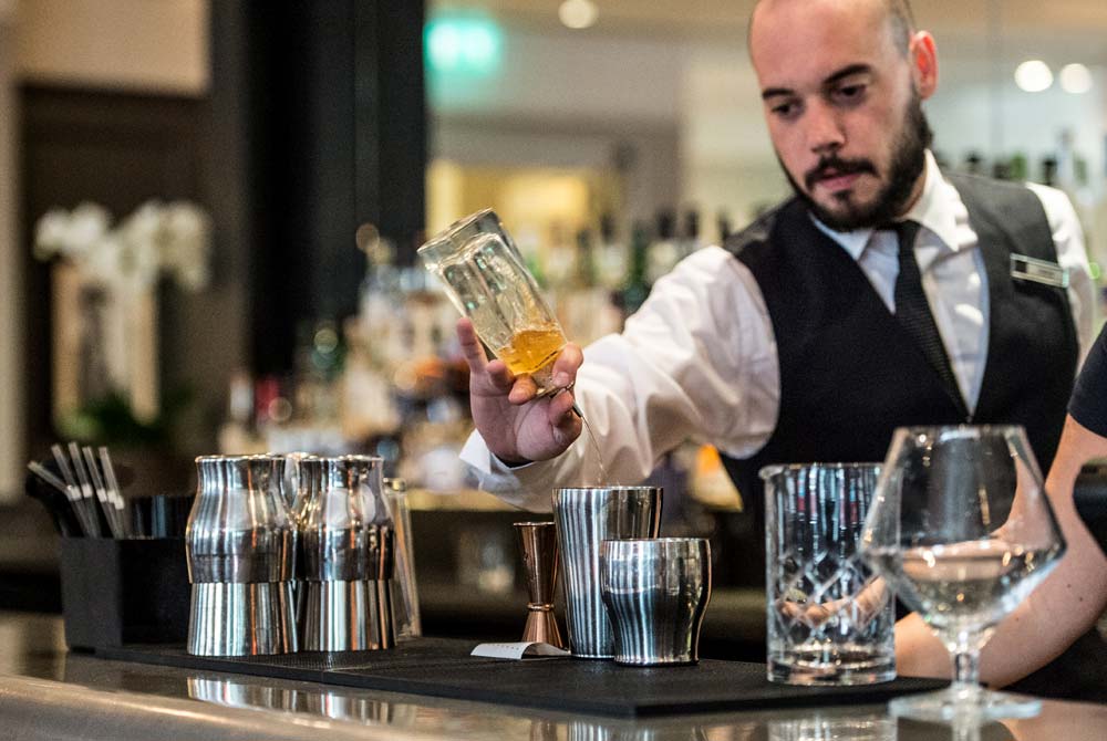 A bartender pouring smooth drinks from behind the bar